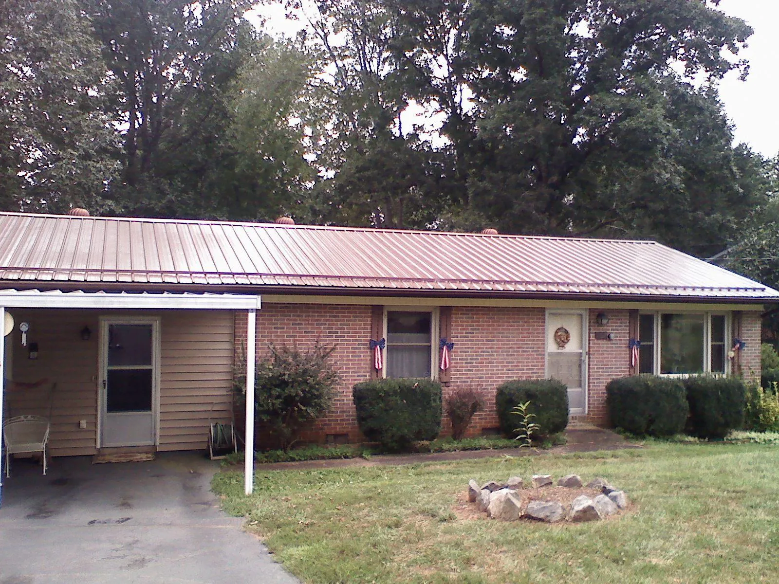 Bronze metal roof and carport on a brick ranch home — Roof Repair work by our crew in Wasco