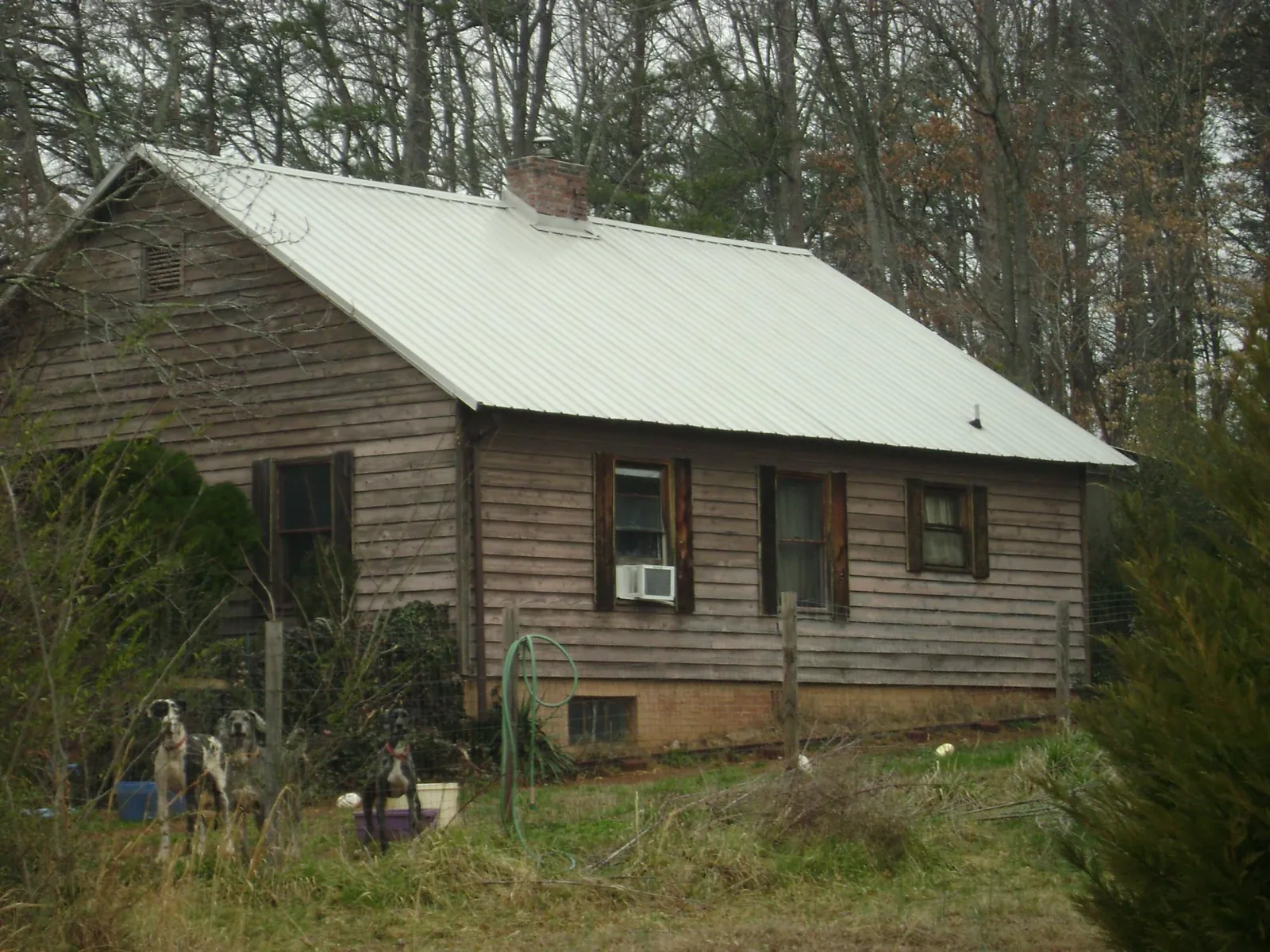 White metal roof on an old wood sided farmhouse, from a Metal Roof Installation job in Wasco